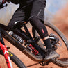 Fasthouse Men's Crossline Bike Shorts - Black man riding a mountain bike